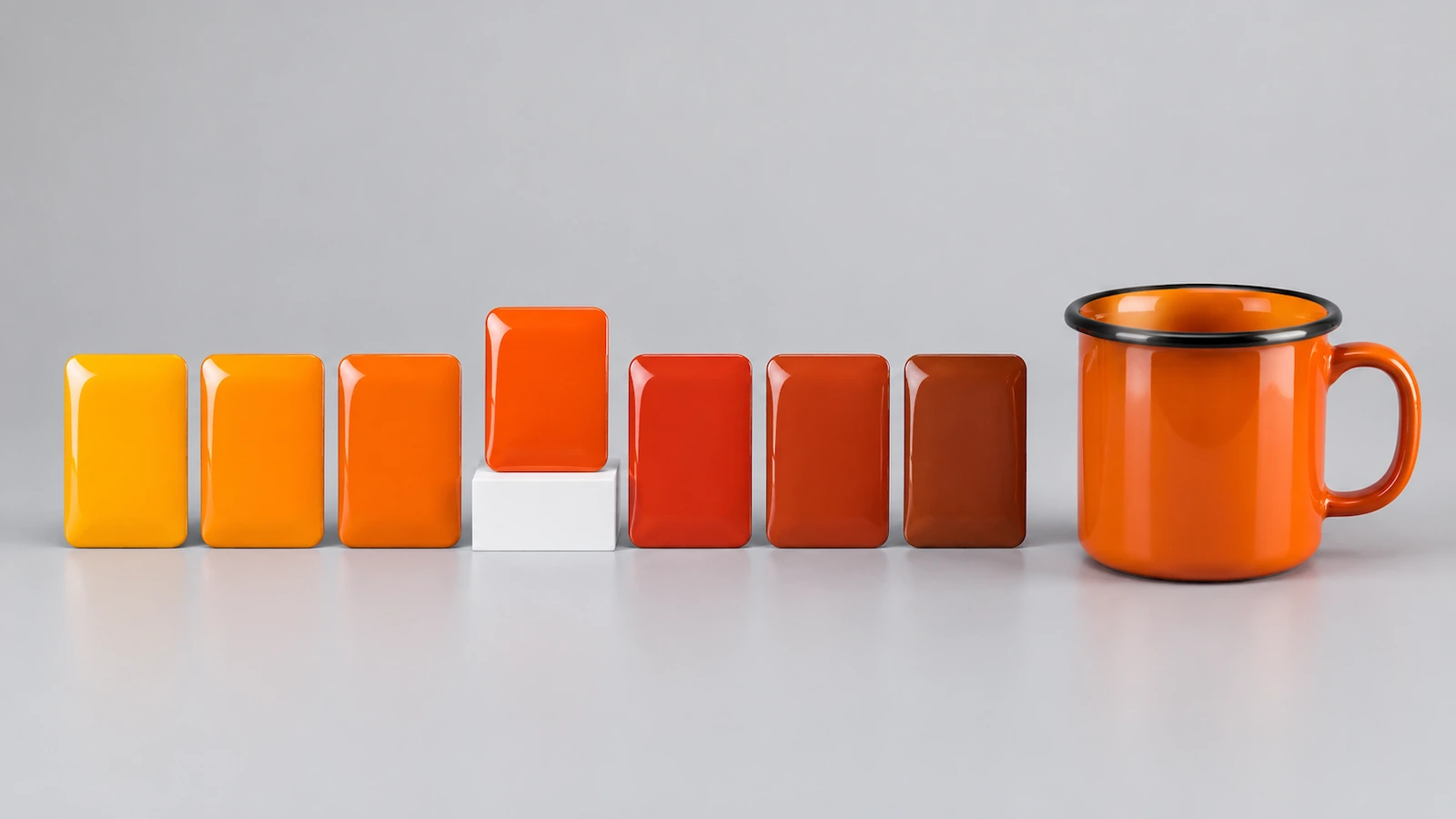 Reihe gebrannter orangefarbener Emaille-Farbplättchen von leuchtendem Mandarine bis zu dunklem Rostbraun neben einem glänzenden orangefarbenen Emaille-Campingbecher