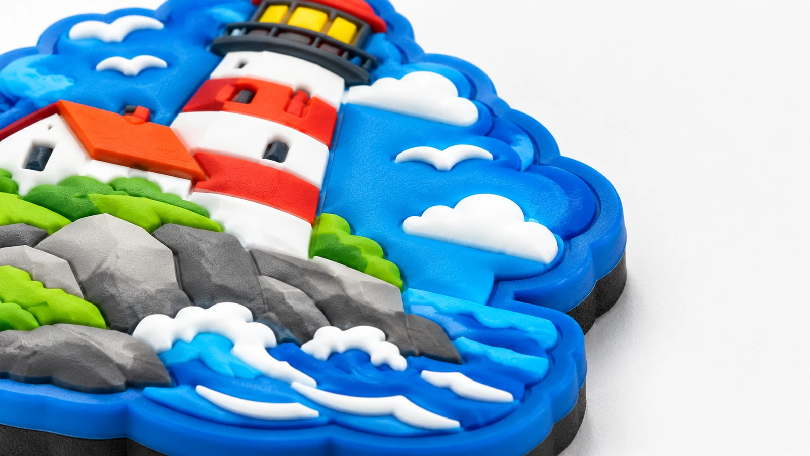 Erhabene Details des Leuchtturm-Magneten Nahaufnahme des erhabenen Leuchtturms sowie von Felsen, Wellen und Wolkendetails auf einem blauen Magneten
