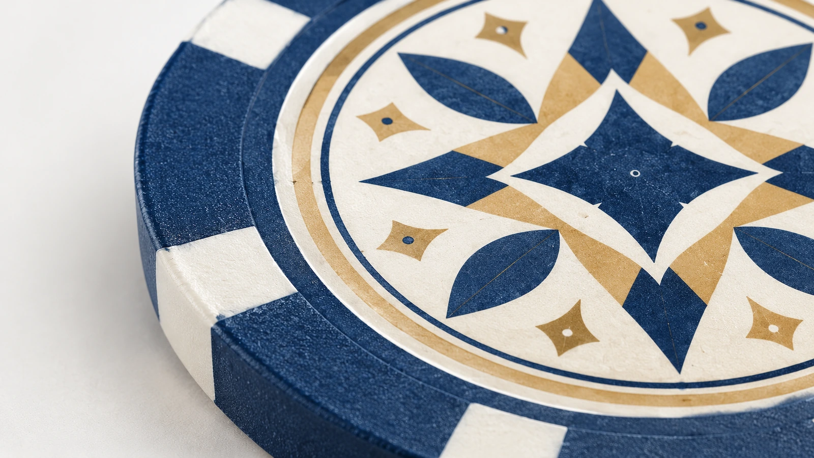 Nahaufnahme eines geometrischen Designs in Blau und Gold auf einem Poker-Chip mit weißen Edge-Spots