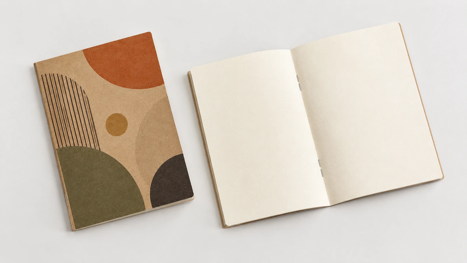 Beispielhaftes geschlossenes Kraftkarton-Notizbuch mit geometrischem Muster neben einem aufgeschlagenen leeren Notizbuch