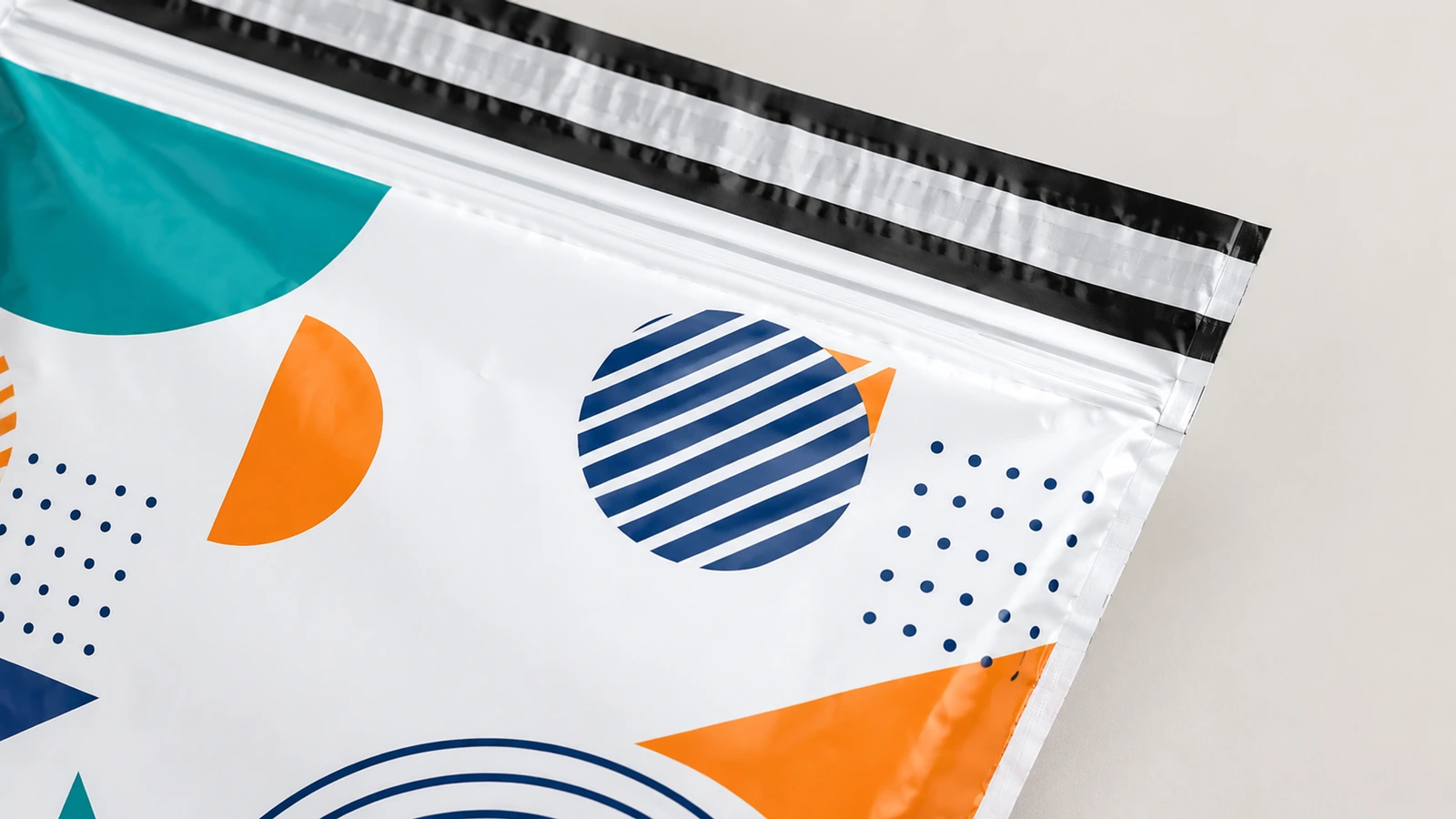 Detail der bedruckten Oberkante einer Versandtasche Nahaufnahme einer Illustration mit geometrischem Motiv und parallelen schwarzen Streifen an der Oberkante einer Versandtasche